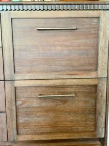 Two-drawer wooden cabinet with metal handles and light wood frame